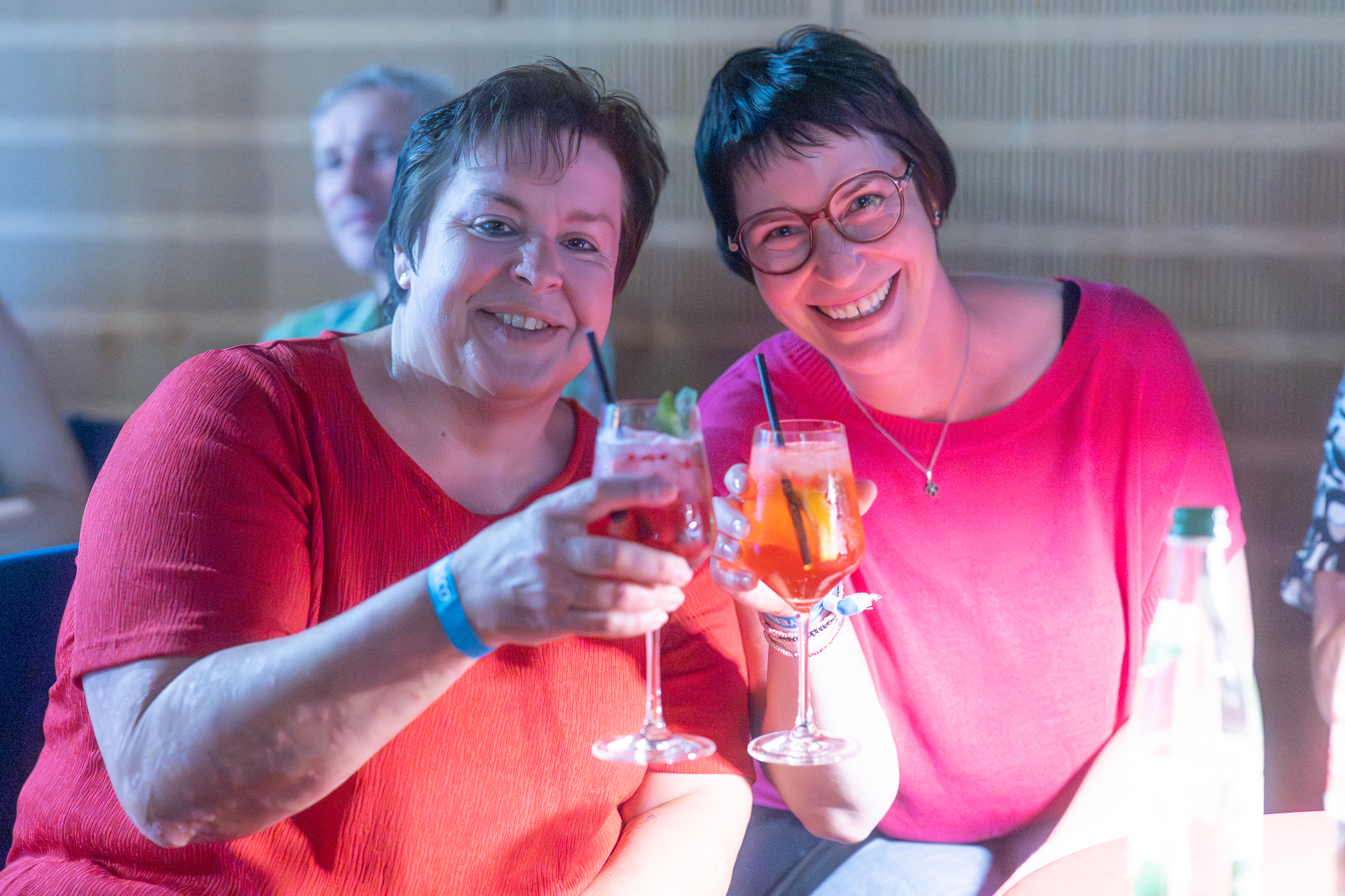 Zwei Besucherinnen stoßen mit Cocktails an