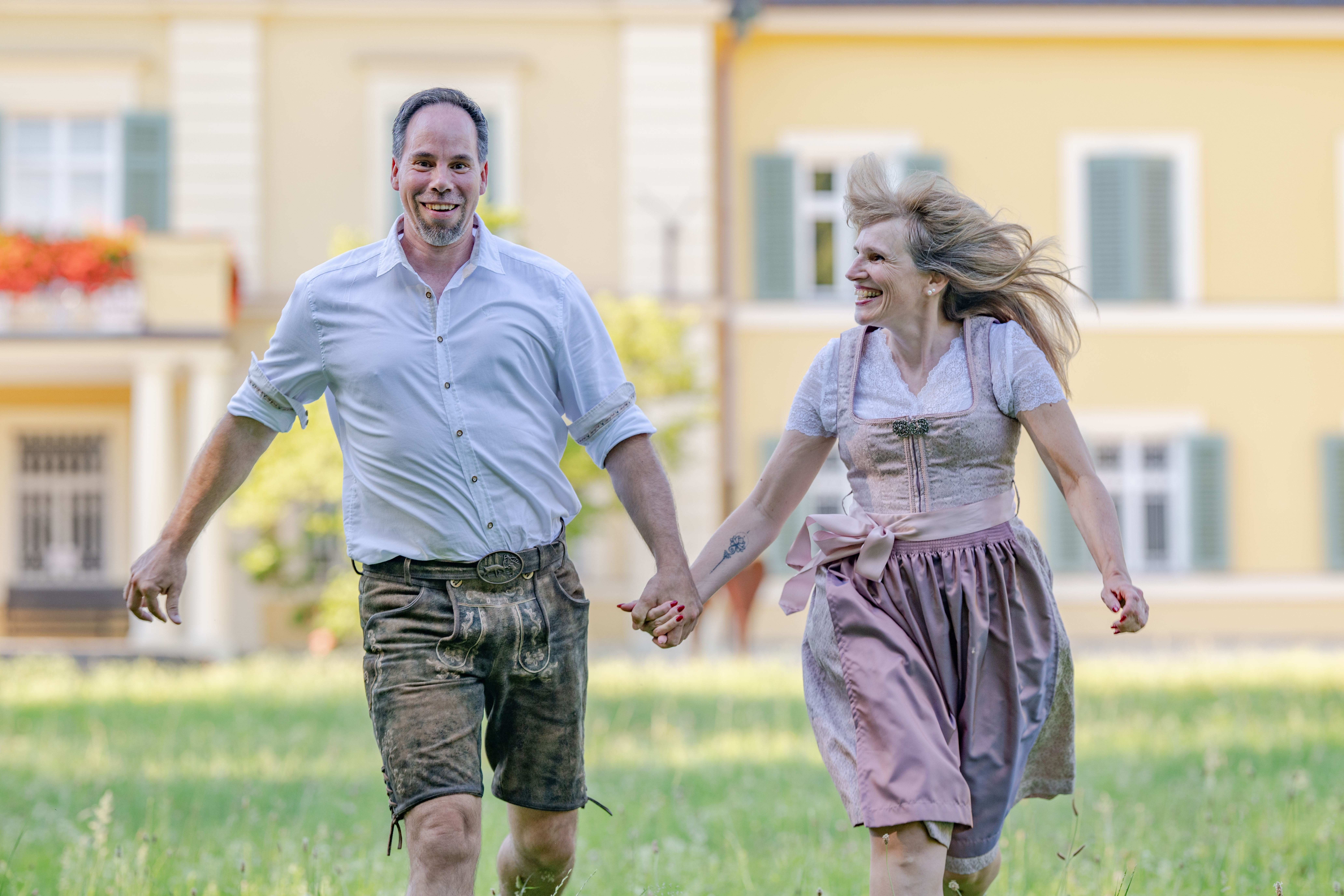 Petra und Markus laufen lachend und Hand in Hand